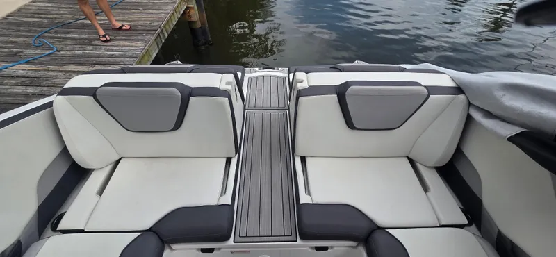 Slide: The Image of 2023 Yamaha Boats 252SD interior with sleek seating and modern design by the water. - 28