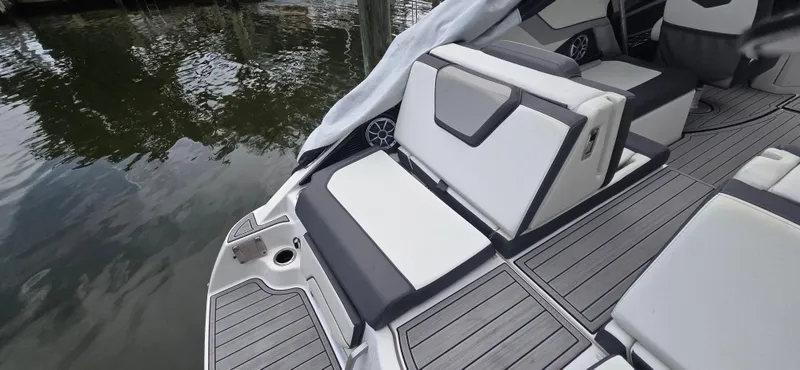 Slide: The Image of 2023 Yamaha Boats 252SD interior with sleek seating and modern design by the water. - 31