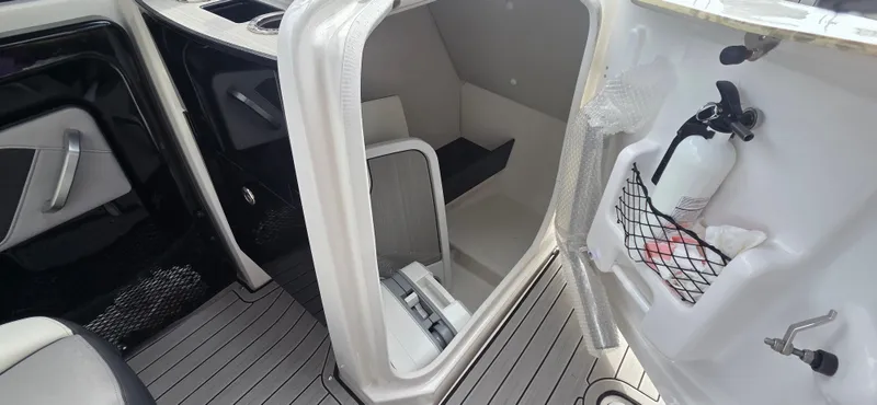 Slide: The Image of 2023 Yamaha Boats 252SD interior storage compartment with fire extinguisher and modern design. - 9