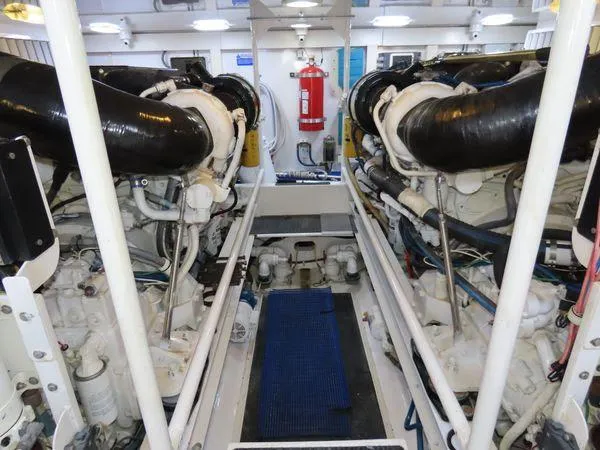 Slide: The Image of Engine room of 2009 Viking 64 Convertible yacht, featuring dual engines and fire extinguisher. - 14