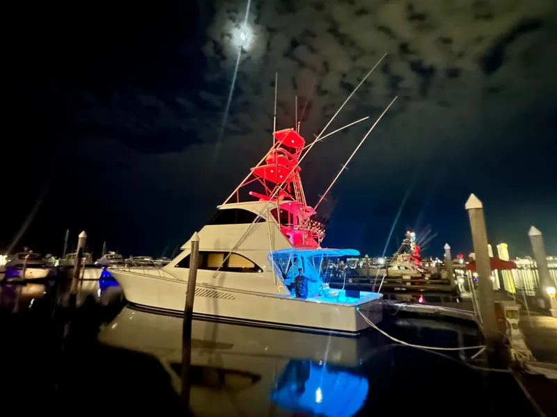 Slide: The Image of 2009 Viking 64 Convertible yacht illuminated at night in a marina. - 2