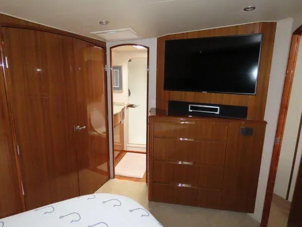 Slide: The Image of Luxurious cabin interior of 2009 Viking 64 Convertible yacht with TV and wooden cabinetry. - 37