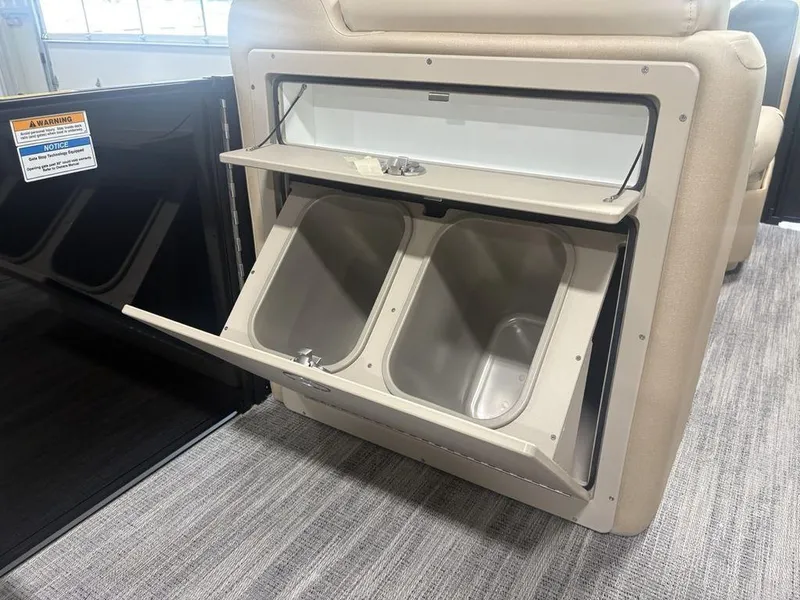 Slide: The Image of Storage compartment in 2025 Godfrey Sweetwater 2286 SFLC boat, featuring dual bins and beige interior. - 19