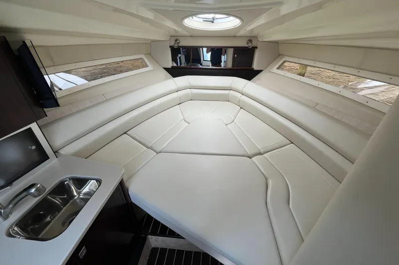 Slide: The Image of 2016 Monterey 295 Sport Yacht interior with white seating, sink, and windows. - 26
