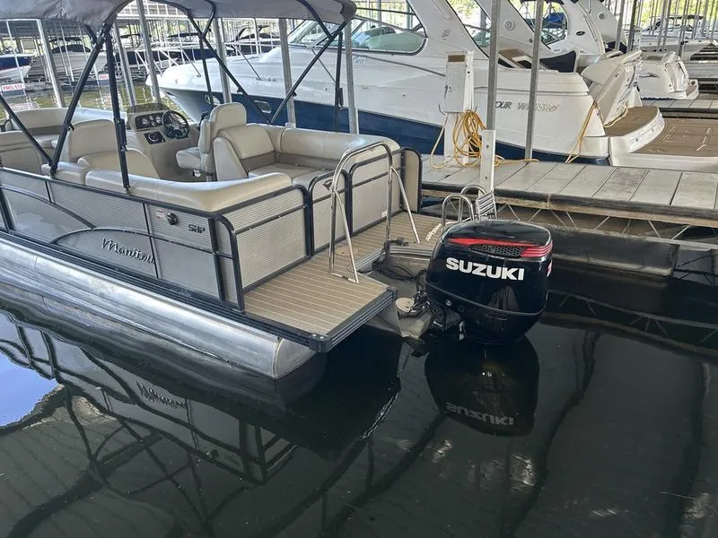 Slide: The Image of 2019 Manitou 250 SHP pontoon boat with Suzuki outboard motor docked in marina. - 4