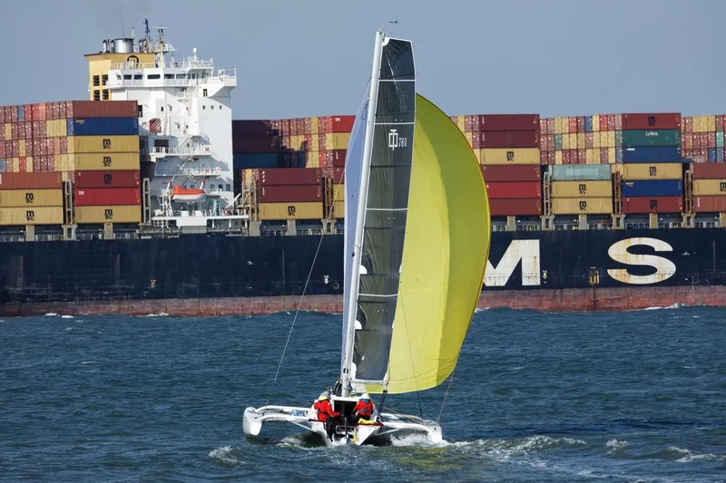 Slide: The Image of Sailboat Corsair 760 Dash 2018 navigating near a large container ship. - 3