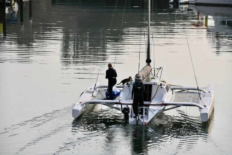 Slide: The Image of 2018 Corsair 760 Dash trimaran sailing with two people and a dog on calm water. - 8