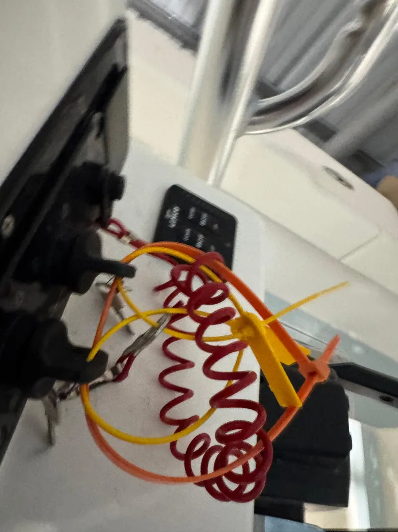 Slide: The Image of 2023 Calypso Center Console boat dashboard with coiled safety lanyard and control panel. - 10