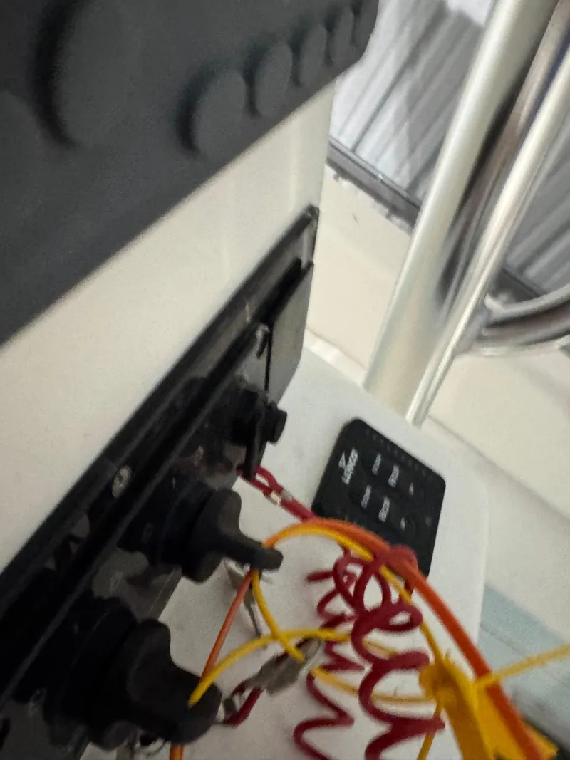 Slide: The Image of 2023 Calypso Center Console boat dashboard with control panel and coiled safety lanyard. - 13