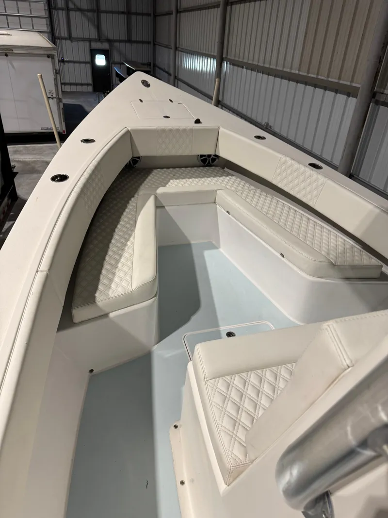 Slide: The Image of 2023 Calypso Center Console boat interior with cushioned seating in a storage facility. - 14