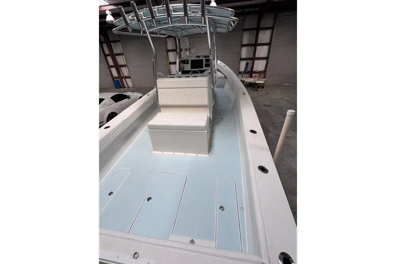 Slide: The Image of 2023 Calypso Center Console boat in a warehouse, featuring sleek design and spacious seating. - 25