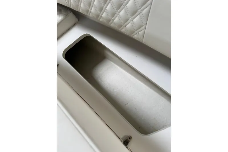 Slide: The Image of 2023 Calypso Center Console boat storage compartment with quilted upholstery detail. - 26