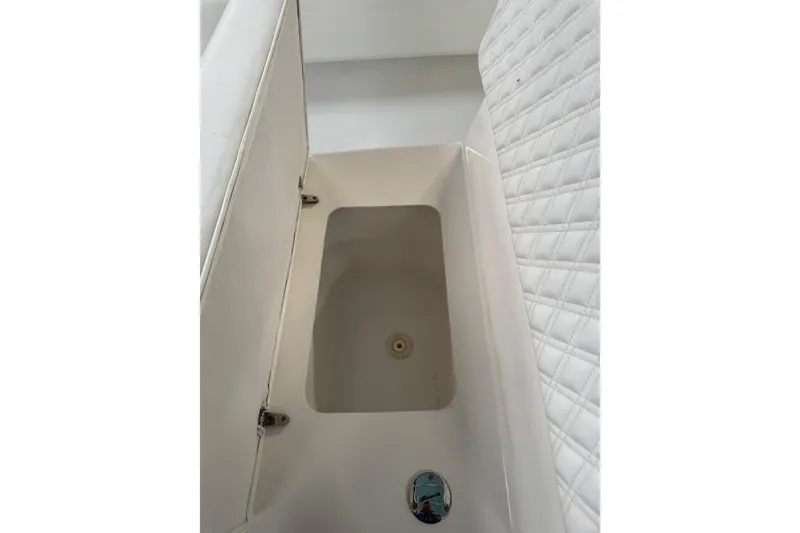 Slide: The Image of 2023 Calypso Center Console boat storage compartment with white cushioned seating. - 28