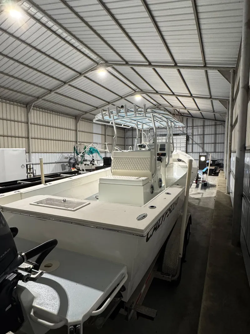 Slide: The Image of 2023 Calypso Center Console boat in a spacious indoor storage facility. - 5