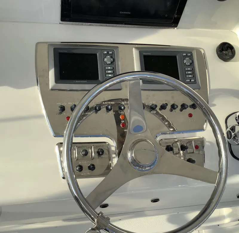 Slide: The Image of Steering wheel and controls of a 2006 Cabo 35 Flybridge Sportfisher boat. - 10