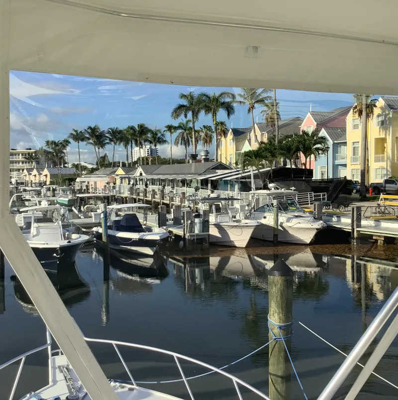 Slide: The Image of Marina view with boats, including a 2006 Cabo 35 Flybridge Sportfisher, and colorful buildings. - 13