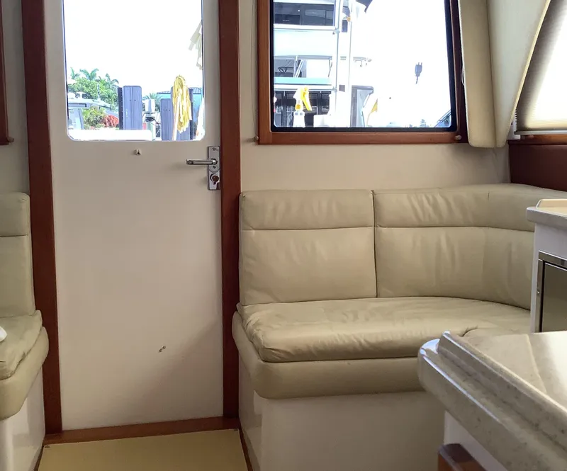 Slide: The Image of Interior of 2006 Cabo 35 Flybridge Sportfisher with beige leather seating and wooden accents. - 14