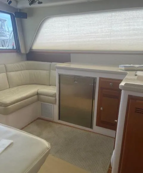 Slide: The Image of 2006 Cabo 35 Flybridge Sportfisher interior with beige seating and compact kitchenette. - 16