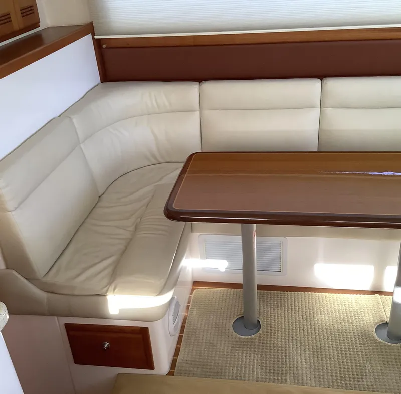 Slide: The Image of 2006 Cabo 35 Flybridge Sportfisher interior with beige seating and wooden table. - 19