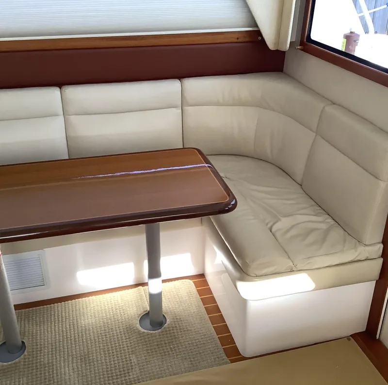 Slide: The Image of 2006 Cabo 35 Flybridge Sportfisher interior with beige seating and wooden table. - 20