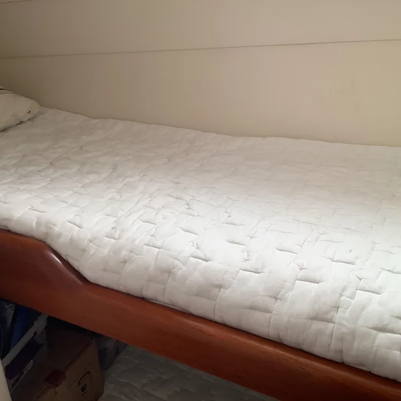 Slide: The Image of 2006 Cabo 35 Flybridge Sportfisher cabin with a neatly made bed and wooden frame. - 23