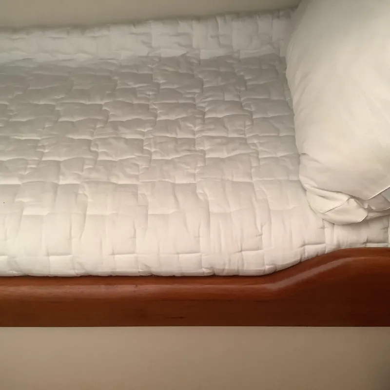 Slide: The Image of White quilted bed on 2006 Cabo 35 Flybridge Sportfisher boat, featuring wooden trim. - 24