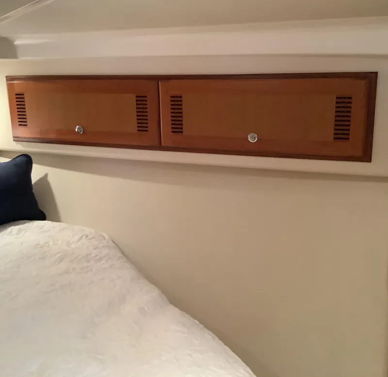 Slide: The Image of 2006 Cabo 35 Flybridge Sportfisher cabin with wooden storage cabinets and bed. - 26