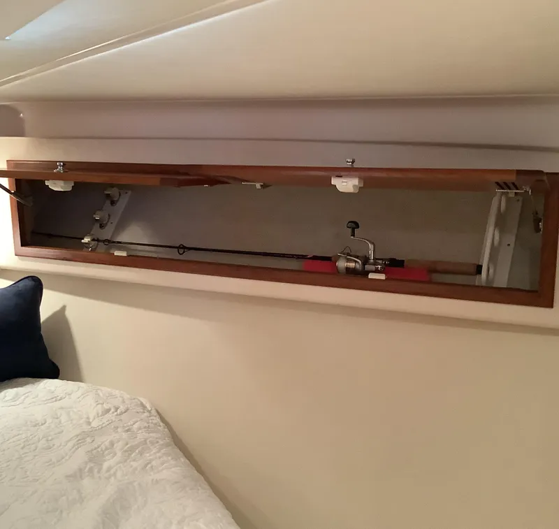 Slide: The Image of Fishing rod storage in 2006 Cabo 35 Flybridge Sportfisher cabin, featuring wooden compartment. - 27