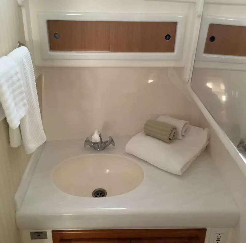 Slide: The Image of 2006 Cabo 35 Flybridge Sportfisher bathroom sink with towels and mirror. - 31