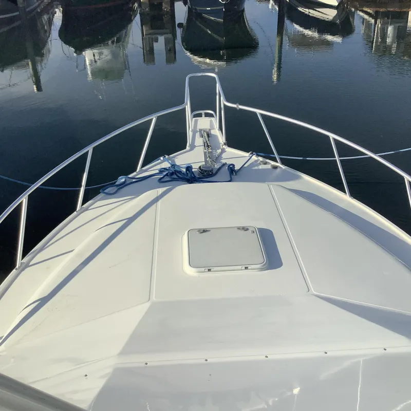 Slide: The Image of Bow view of 2006 Cabo 35 Flybridge Sportfisher in a marina. - 4