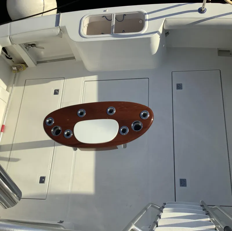 Slide: The Image of 2006 Cabo 35 Flybridge Sportfisher deck with fishing rod holders and storage compartments. - 7