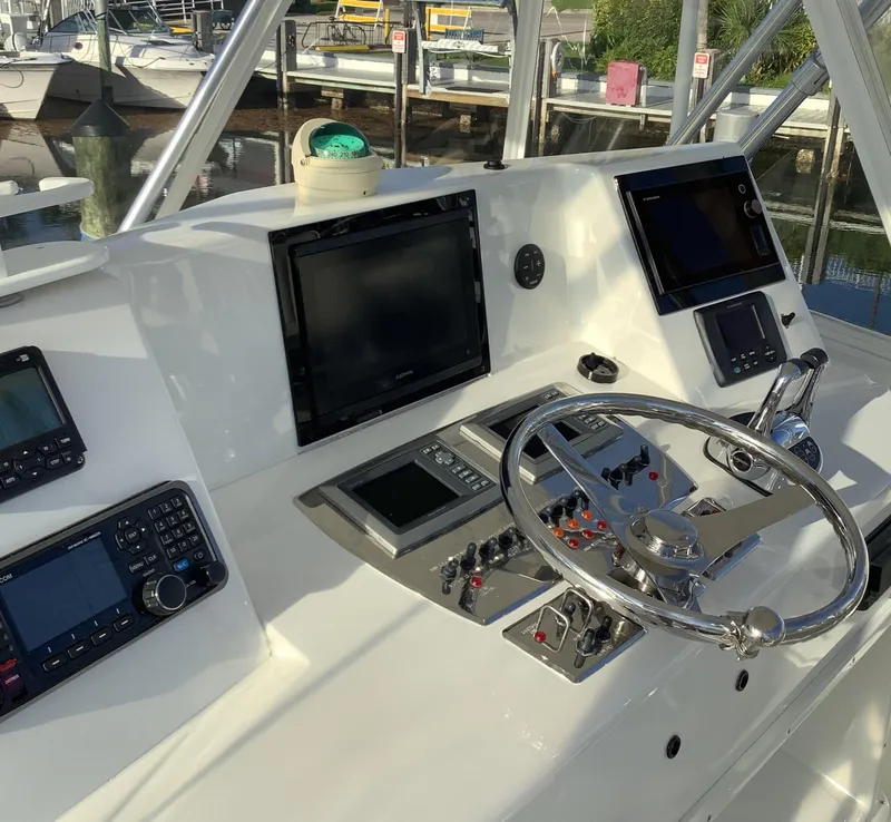 Slide: The Image of 2006 Cabo 35 Flybridge Sportfisher helm with advanced navigation equipment and steering wheel. - 9
