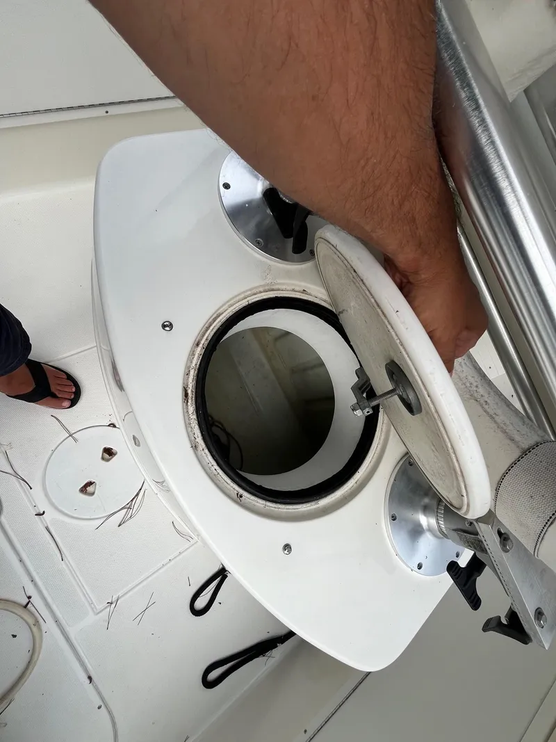Slide: The Image of A person opening a hatch on a 2000 Wellcraft 302 SCARAB SPORT boat. - 11