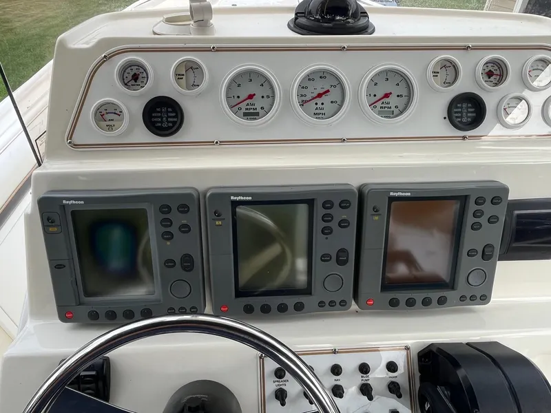 Slide: The Image of Dashboard of 2000 Wellcraft 302 SCARAB SPORT with gauges and Raytheon displays. - 13