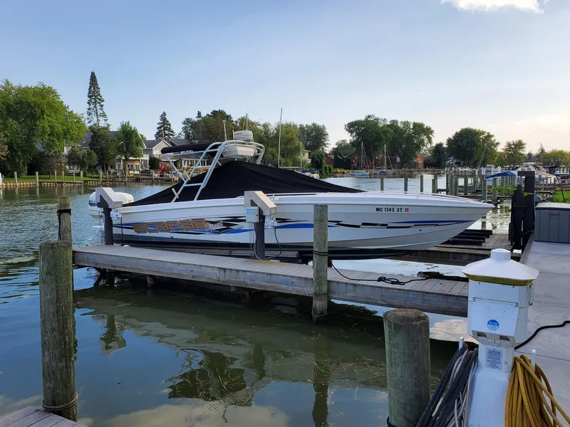 Slide: The Image of 2000 Wellcraft 302 SCARAB SPORT boat docked at a marina, covered and ready for use. - 5