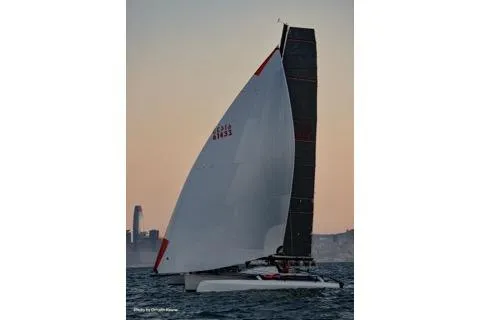 Slide: The Image of 2005 Marstrom Seacart 30 sailing at sunset with city skyline in background. - 14