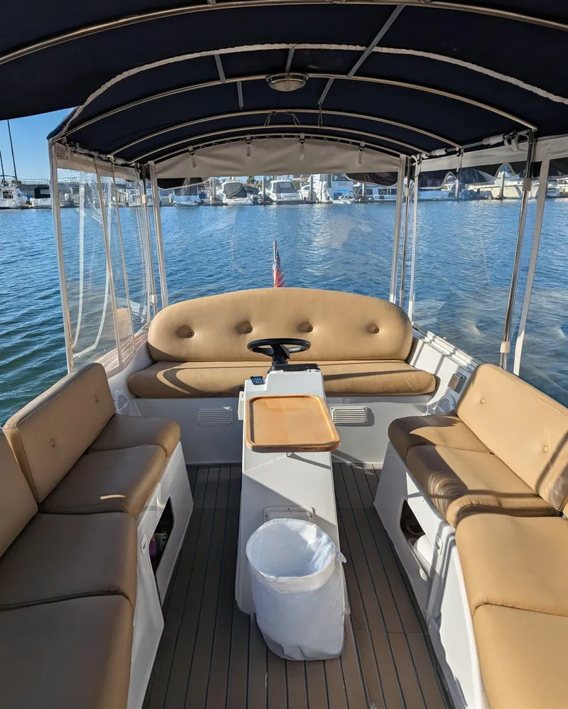 Slide: The Image of Interior of a 2004 Duffy 21 boat with tan seating and a covered canopy. - 2