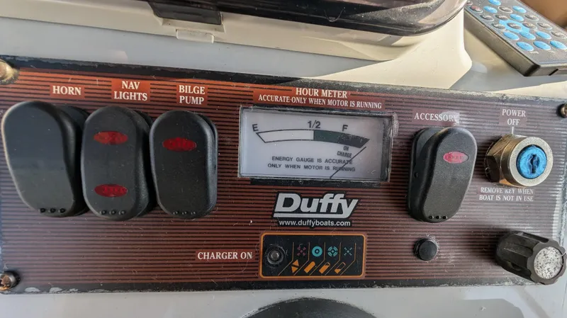 Slide: The Image of Control panel of a 2004 Duffy 21 boat with switches and hour meter. - 4