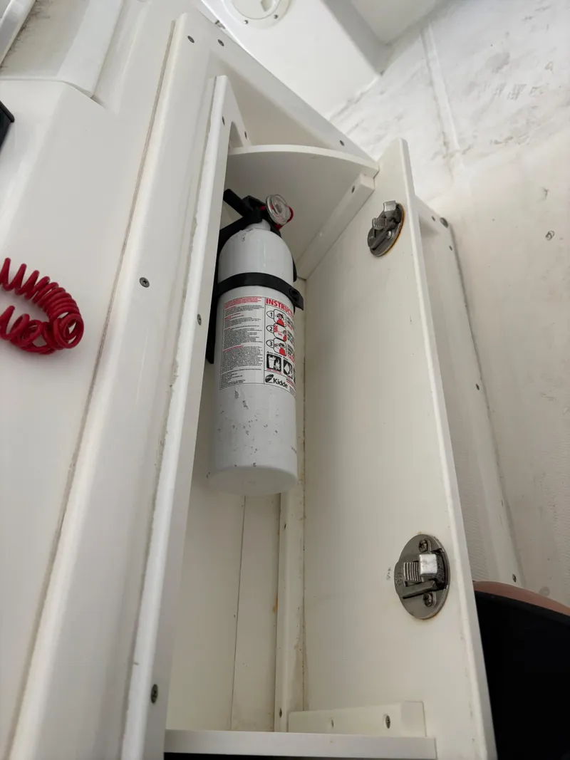 Slide: The Image of Fire extinguisher in a 2005 Regulator 24 Classic boat compartment. - 15