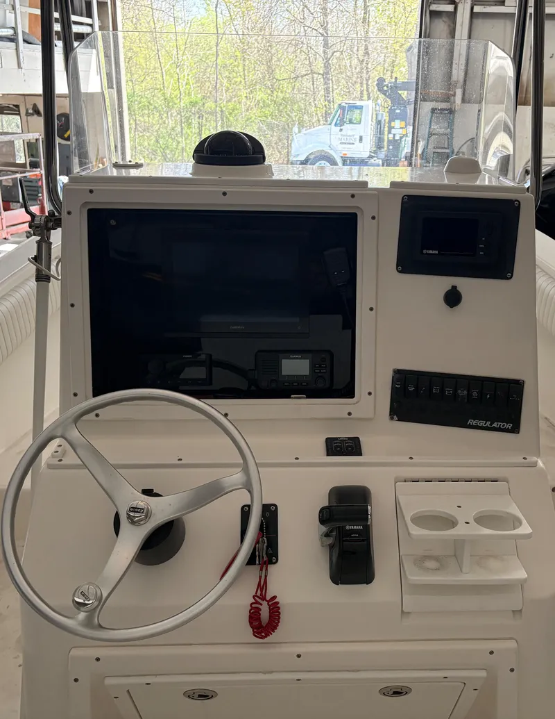 Slide: The Image of 2005 Regulator 24 Classic boat dashboard with steering wheel and control panel. - 17