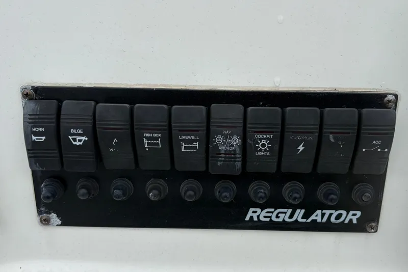 Slide: The Image of Control panel of a 2005 Regulator 24 Classic boat with labeled switches. - 22