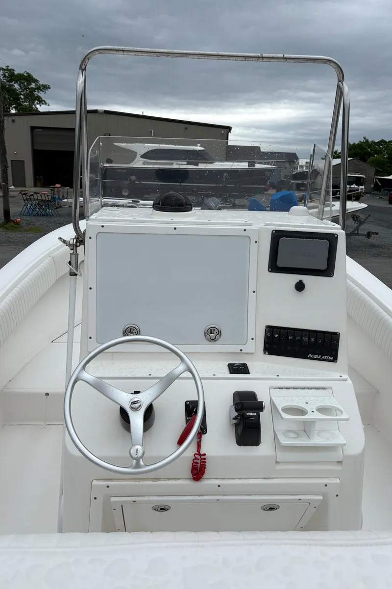 Slide: The Image of 2005 Regulator 24 Classic boat console with steering wheel and controls, overcast sky background. - 7