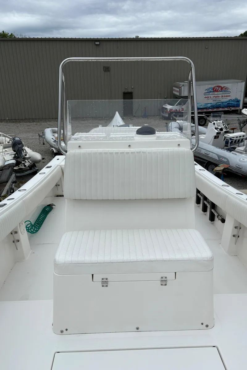 Slide: The Image of 2005 Regulator 24 Classic boat with white seating and console, docked outdoors. - 8