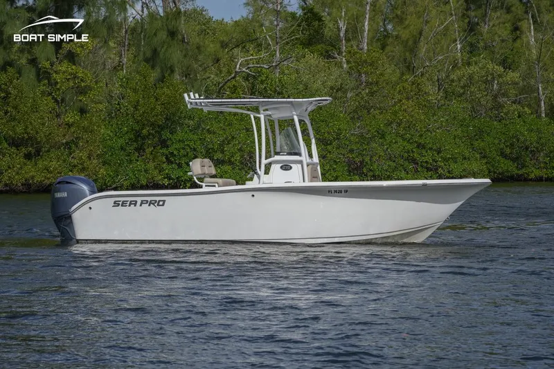 Slide: The Image of 2023 Sea Pro 219 Deep V CC boat on calm water, surrounded by lush greenery. - 1