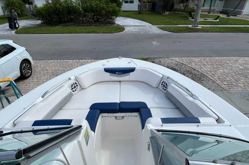 Slide: The Image of 2021 Robalo 207R boat with white and blue seating, parked on a driveway. - 3