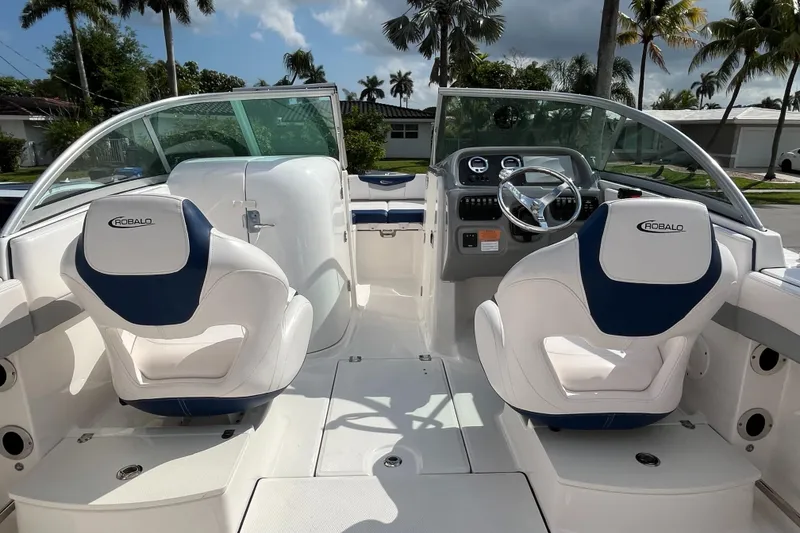 Slide: The Image of 2021 Robalo 207R boat interior with dual white and blue seats, steering wheel, and dashboard. - 6