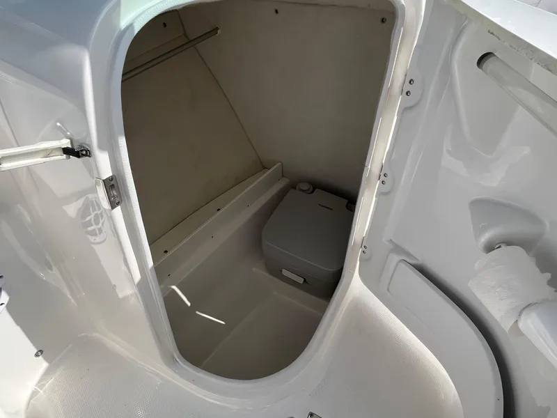 Slide: The Image of 2021 Robalo 207R boat interior with compact marine toilet. - 7