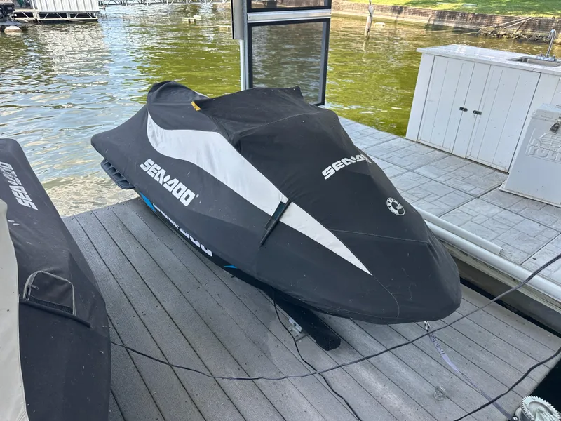 Slide: The Image of 2017 Sea-Doo RXT 260 jet ski covered on a dock by the water. - 14