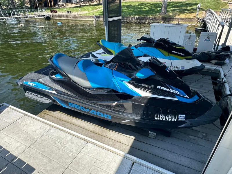 Slide: The Image of 2017 Sea-Doo RXT 260 jet ski docked on a sunny lakeside pier. - 2