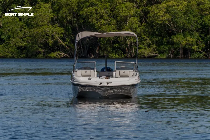 Slide: The Image of 2022 Hurricane SunDeck 217 OB boat on calm water with lush green background. - 3